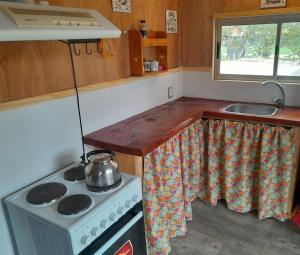 a small kitchen with a stove and a sink at Cabaña para Desconectar in Barra de Portezuelo