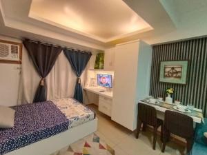 a bedroom with a bed and a desk and a table at Avida tower 1 L21 staycation condotel rm1002 in Iloilo City +27 photos