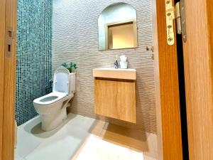 a bathroom with a toilet and a sink and a mirror at Sunny 3 bedrooms Apartment - balcony and workspace in Kenitra +15 photos