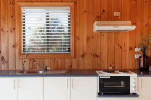 a kitchen with a sink and a window at Panorama Cabin - A in Bicheno