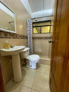 a bathroom with a toilet and a sink at Cabaña Flor Hermosa in Santo Domingo de los Colorados
