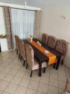a dining room with a black table and brown chairs at SarafuDeluxe in Nakuru