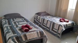 two beds sitting next to each other in a bedroom at Casa Novinha na Praia in Cabo Frio