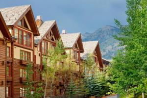 a row of houses with mountains in the background at Snake River Lodge in Teton Village