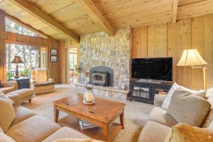 a living room with a stone fireplace and a tv at Waterfront Escape on Big Sand Lake with Private Dock in Minong