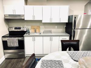 a kitchen with white cabinets and a stainless steel refrigerator at Heaven on Earth in Ajax +19 photos