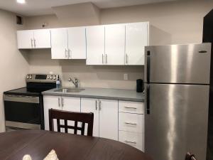 a kitchen with white cabinets and a stainless steel refrigerator at Heaven on Earth in Ajax