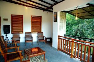 a porch with chairs and a table and a television at The Paddy View Villa in Dickwella +37 photos