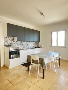 a kitchen with a table and chairs in a kitchen at La casa di Princess in Cava D'aliga