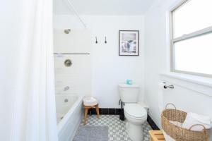 a white bathroom with a toilet and a bath tub at Lovely 1 bedroom 1 bathroom Downtown Long Beach Apartment in Long Beach +75 photos