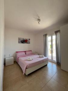 a bedroom with a large bed with pink sheets at La casa di Princess in Cava dʼAliga