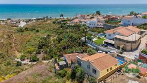 eine Luftaufnahme eines Hauses und des Ozeans in der Unterkunft Family cottage in Benajarafe w pool and sea view in Vélez-Málaga