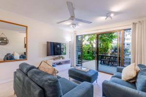 Una sala de estar con dos sofás y un televisor. en Sandy Toes, en Port Douglas