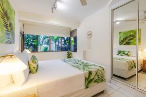 un dormitorio con una cama y un espejo en Sandy Toes, en Port Douglas 14 fotos más