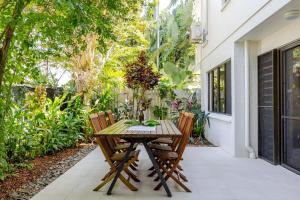 Una mesa y sillas de madera en un patio. en Sandy Toes, en Port Douglas