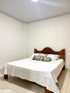 a bedroom with a bed with white sheets and pillows at Acogedor apartamento in Leticia