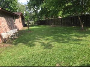 a yard with chairs and a fence and a tree at Serenity Retreat near Camp Lejeune & Beaches in Jacksonville
