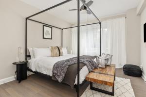 een slaapkamer met een zwart hemelbed en een houten tafel bij Refined 2BR King Suite with Gym and Lounge - The MORGAN in Arlington +15 foto's