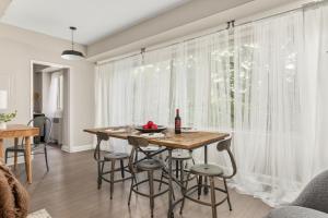 een eetkamer met een tafel en stoelen voor een raam bij Refined 2BR King Suite with Gym and Lounge - The MORGAN in Arlington