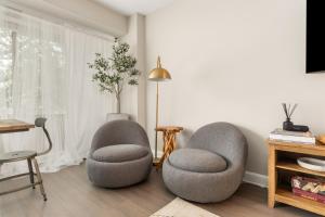 twee stoelen in een woonkamer naast een raam bij Refined 2BR King Suite with Gym and Lounge - The MORGAN in Arlington