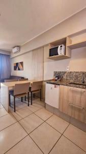 une cuisine et une salle à manger avec une table et des chaises dans l'établissement Barretos Country Resort - Apto 1 Quarto até 5 Pessoas, à Barretos
