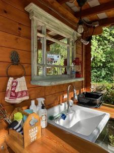 a kitchen sink in a cabin with a window at Idyllic Cabin Retreat Only 5 Minutes Away From Nelson in Nelson