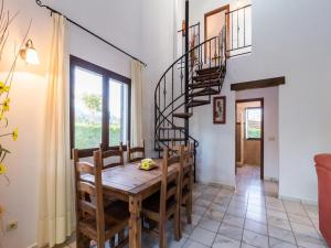 a dining room with a wooden table and a spiral staircase at Countryside Escape in Andalusia for 6 in Cuenca