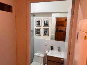 ein Badezimmer mit Toilette, Waschbecken und Spiegel in der Unterkunft Tempo Moderno Departamento in San Antonio + 8 Fotos