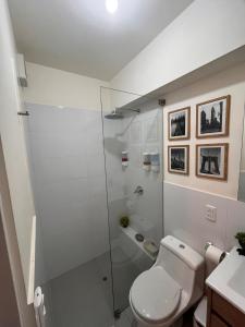 ein Badezimmer mit Toilette und Glasdusche in der Unterkunft Tempo Moderno Departamento in San Antonio