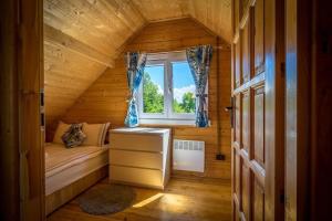 una piccola camera in una baita di tronchi con finestra di Comfortable holiday homes with a pool a Ustronie Morskie Altre 22 foto