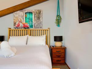 a bedroom with a white bed and a green door at Sunshine Bay Serenity Beachside Escape in Denhams Beach