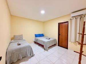 une chambre avec deux lits et une fenêtre dans l'établissement Seu Refúgio em carneiros 3 Quartos C Ar, piscina privativa, à Tamandaré 29 autres photos