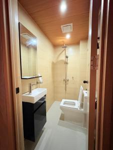 a bathroom with a toilet and a sink and a mirror at Tagosilangan Beach House in Buruanga +60 photos