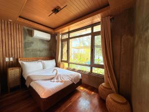 a bedroom with a bed with a large window at Tagosilangan Beach House in Buruanga