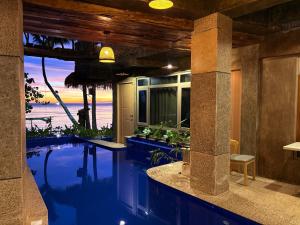 a house with a swimming pool with a view of the ocean at Tagosilangan Beach House in Buruanga