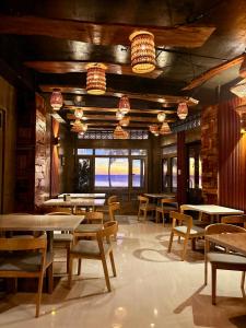 a restaurant with tables and chairs and chandeliers at Tagosilangan Beach House in Buruanga