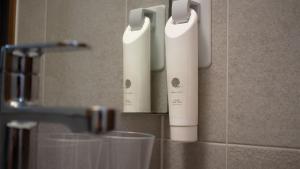 two white electric toothbrushes on a wall in a bathroom at Ramada by Wyndham Gumi in Gumi +43 photos