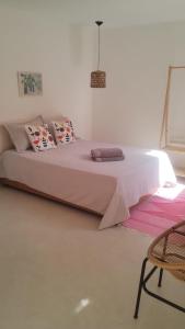 a bedroom with a large bed with pink sheets and pillows at Suíte 5 Vila dos Pescadores Cond Portogalo in Angra dos Reis