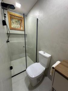 a bathroom with a toilet and a shower at Suíte 5 Vila dos Pescadores Cond Portogalo in Angra dos Reis