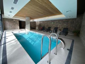 basen w budynku z krzesłami wokół niego w obiekcie Depto 2D2B Piscina y jacuzzi, a pasos de la playa w mieście Puerto Varas