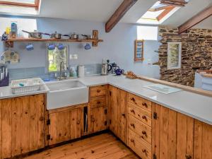 a kitchen with wooden cabinets and a sink at New England-Uk12750 in Menheniot