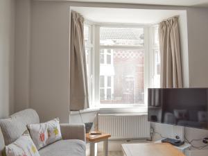 a living room with a couch and a large window at Newstead Cottage in Weymouth