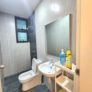 Un baño con inodoro, lavabo y espejo. en Skyhomes KLCC New, en Kuala Lumpur