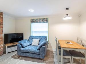 a living room with a blue chair and a table at Salem Porter- Uk34814 in Tattershall