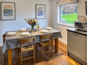 a kitchen with a table with four chairs and a tableablish at The Lodge in Fowey +22 photos