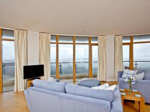 Una sala de estar con dos sofás y un televisor. en Pebbles, Horizon View, en Westward Ho