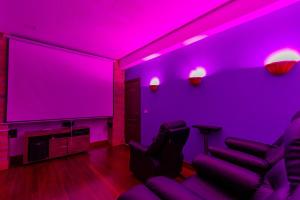 a living room with purple lighting and a large screen at AEROPUERTO-Rionegro- MONTEOLIVO COLONIAL in Rionegro