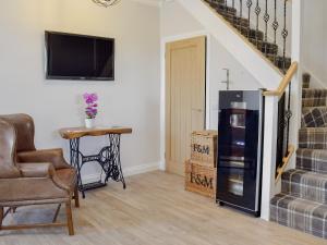 a living room with a chair and a refrigerator at Smithfield House in Tarbolton