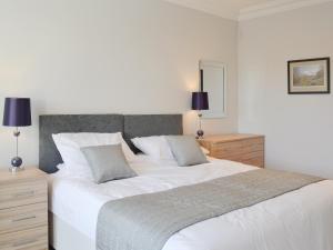 a bedroom with a large white bed with two pillows at Smithfield House in Tarbolton +23 photos