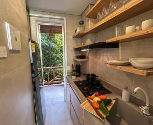 a small kitchen with a stove and vegetables on a counter at Despierta en Tolú, un escenario de película in Tolú